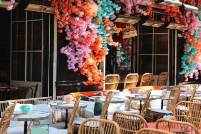 Plateau avec un café, un cannelé, une tartelette, une brioche, de la crème et des verres sur une table rouge.