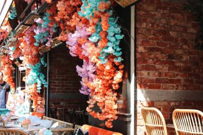 Plateau avec un café, un cannelé, une tartelette, une brioche, de la crème et des verres sur une table rouge.