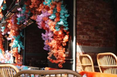 Plateau avec un café, un cannelé, une tartelette, une brioche, de la crème et des verres sur une table rouge.