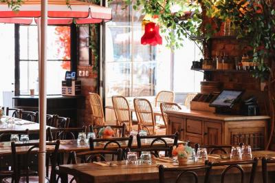 Plateau avec un café, un cannelé, une tartelette, une brioche, de la crème et des verres sur une table rouge.