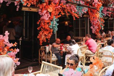 Plateau avec un café, un cannelé, une tartelette, une brioche, de la crème et des verres sur une table rouge.