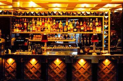 Verre à cocktail rempli d'un espresso martini, garni de grains de café, avec un fond sombre et texturé.