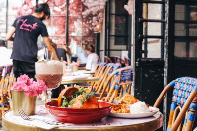 Assiette de sandwichs triangulaires et planche de pizza garnie de mozzarella et tomates, avec verres de vin rouge.