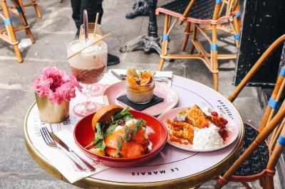 Assiette de sandwichs triangulaires et planche de pizza garnie de mozzarella et tomates, avec verres de vin rouge.