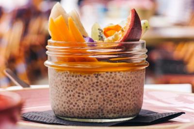 Assiette de sandwichs triangulaires et planche de pizza garnie de mozzarella et tomates, avec verres de vin rouge.