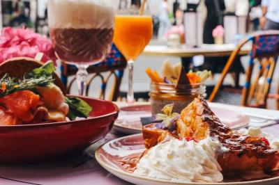 Assiette de sandwichs triangulaires et planche de pizza garnie de mozzarella et tomates, avec verres de vin rouge.