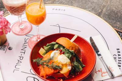 Assiette de sandwichs triangulaires et planche de pizza garnie de mozzarella et tomates, avec verres de vin rouge.