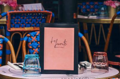 Assiette de sandwichs triangulaires et planche de pizza garnie de mozzarella et tomates, avec verres de vin rouge.