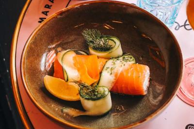 Assiette de sandwichs triangulaires et planche de pizza garnie de mozzarella et tomates, avec verres de vin rouge.