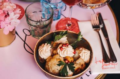 Assiette de sandwichs triangulaires et planche de pizza garnie de mozzarella et tomates, avec verres de vin rouge.