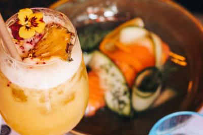 Assiette de sandwichs triangulaires et planche de pizza garnie de mozzarella et tomates, avec verres de vin rouge.