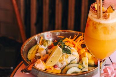 Assiette de sandwichs triangulaires et planche de pizza garnie de mozzarella et tomates, avec verres de vin rouge.