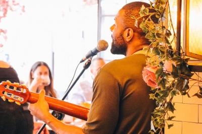 Assiette de sandwichs triangulaires et planche de pizza garnie de mozzarella et tomates, avec verres de vin rouge.