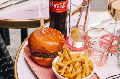 Assiette de sandwichs triangulaires et planche de pizza garnie de mozzarella et tomates, avec verres de vin rouge.