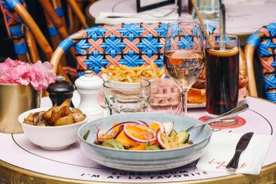 Assiette de sandwichs triangulaires et planche de pizza garnie de mozzarella et tomates, avec verres de vin rouge.