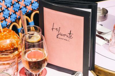 Assiette de sandwichs triangulaires et planche de pizza garnie de mozzarella et tomates, avec verres de vin rouge.