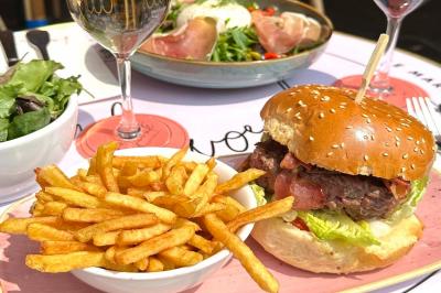 Assiette de sandwichs triangulaires et planche de pizza garnie de mozzarella et tomates, avec verres de vin rouge.