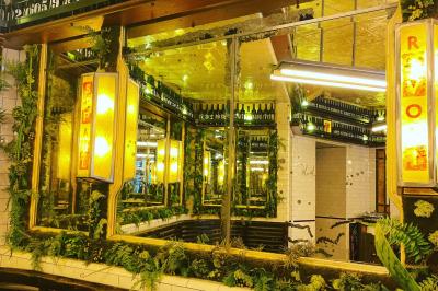 Assiette de sandwichs triangulaires et planche de pizza garnie de mozzarella et tomates, avec verres de vin rouge.