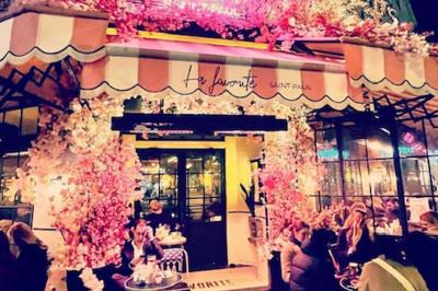 Assiette de sandwichs triangulaires et planche de pizza garnie de mozzarella et tomates, avec verres de vin rouge.