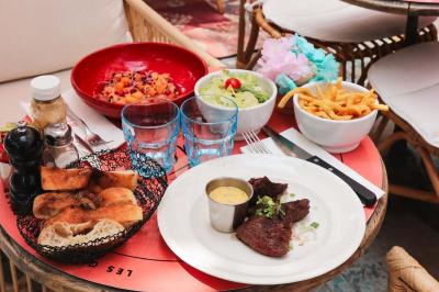 Étagères en bois remplies de bouteilles d'alcool, encadrées de briques et de feuillage, dans un décor de bar chaleureux.