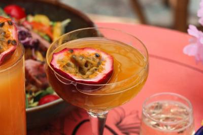 Étagères en bois remplies de bouteilles d'alcool, encadrées de briques et de feuillage, dans un décor de bar chaleureux.