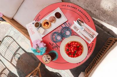 Étagères en bois remplies de bouteilles d'alcool, encadrées de briques et de feuillage, dans un décor de bar chaleureux.
