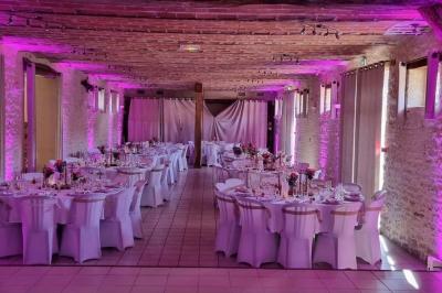 Salle décorée pour une fête, éclairée de lumières violettes, avec des ballons rouges et un chiffre ’18’ en ballons.