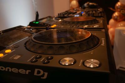 Salle décorée pour une fête, éclairée de lumières violettes, avec des ballons rouges et un chiffre ’18’ en ballons.