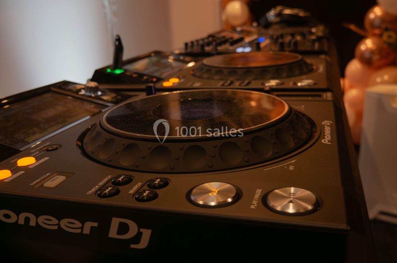 Table de mixage DJ avec platines Pioneer entourée de ballons décoratifs dans un environnement festif.