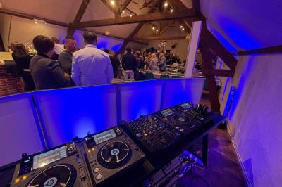 Salle décorée pour une fête, éclairée de lumières violettes, avec des ballons rouges et un chiffre ’18’ en ballons.