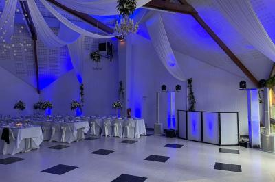 Salle décorée pour une fête, éclairée de lumières violettes, avec des ballons rouges et un chiffre ’18’ en ballons.