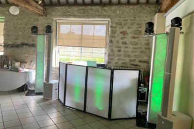 Salle décorée pour une fête, éclairée de lumières violettes, avec des ballons rouges et un chiffre ’18’ en ballons.