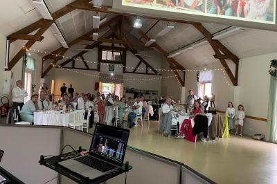 Salle décorée pour une fête, éclairée de lumières violettes, avec des ballons rouges et un chiffre ’18’ en ballons.