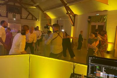 Salle décorée pour une fête, éclairée de lumières violettes, avec des ballons rouges et un chiffre ’18’ en ballons.