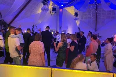 Groupe de personnes dans une salle décorée, dansant et socialisant lors d'un événement festif.