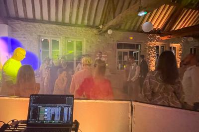 Salle décorée pour une fête avec éclairage violet, ballons rouges formant le chiffre 18 et espace de danse dégagé.