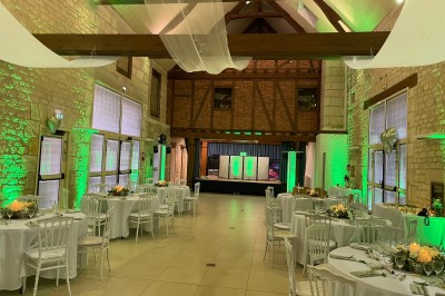 Salle décorée pour une fête avec éclairage violet, ballons rouges formant le chiffre 18 et espace de danse dégagé.
