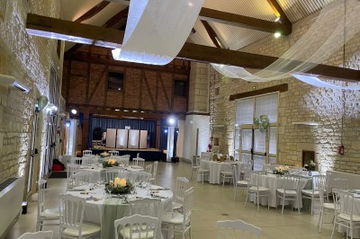 Salle décorée pour une fête avec éclairage violet, ballons rouges formant le chiffre 18 et espace de danse dégagé.