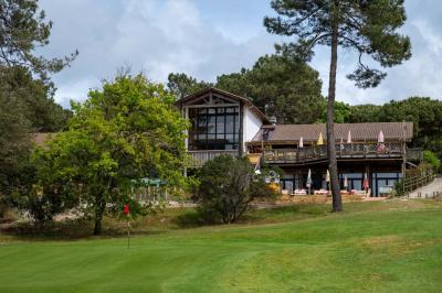 Chambre lumineuse avec lit double, rideaux rouges, balcon donnant sur un espace vert et mobilier minimaliste.