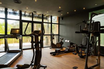 Chambre lumineuse avec lit double, rideaux rouges, balcon donnant sur un espace vert et mobilier minimaliste.