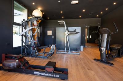 Chambre lumineuse avec lit double, rideaux rouges, balcon donnant sur un espace vert et mobilier minimaliste.