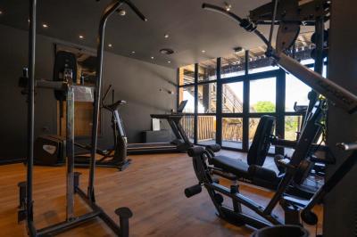 Chambre lumineuse avec lit double, rideaux rouges, balcon donnant sur un espace vert et mobilier minimaliste.
