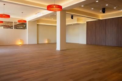 Chambre lumineuse avec lit double, rideaux rouges, balcon donnant sur un espace vert et mobilier minimaliste.