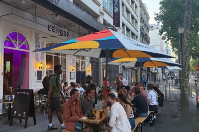 Assiette de charcuterie avec pain, cornichons, tapenade, fromage et beurre, présentée sur une table en bois.