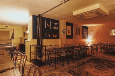 Assiette de charcuterie avec pain, cornichons, tapenade, fromage et beurre, présentée sur une table en bois.