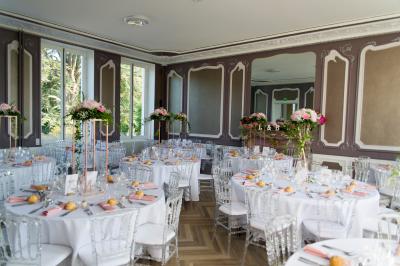 Miniature Location salle La Chapelle-Saint-Mesmin (Loiret) - Chateau du Rollin #24 Salle de réception élégante avec tables rondes dressées, chaises blanches et décorations florales, parquet au sol.