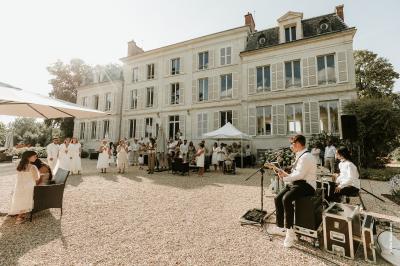 Miniature Location salle La Chapelle-Saint-Mesmin (Loiret) - Chateau du Rollin #30 Salle de réception élégante avec tables rondes dressées, chaises blanches et décorations florales, parquet au sol.