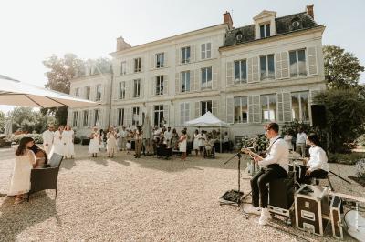 Table dressée avec verres, herbes et ustensiles devant une cheminée décorative dans une pièce éclairée.