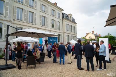 Table dressée avec verres, herbes et ustensiles devant une cheminée décorative dans une pièce éclairée.