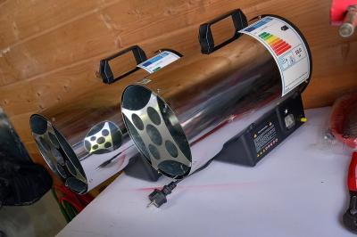 Intérieur d'une tente blanche avec des parois transparentes laissant voir un jardin et une porte en bois.